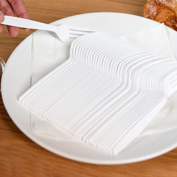 Stack of heavy white disposable forks on napkin placed on plate, 1000 pcs pack, eco friendly cutlery for meals