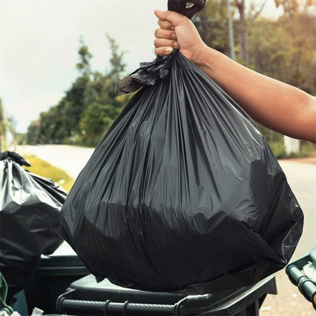Person placing full 46 gallon garbage bag into trash bin – strong tear resistant garbage bag ideal for home kitchen and industrial waste disposal